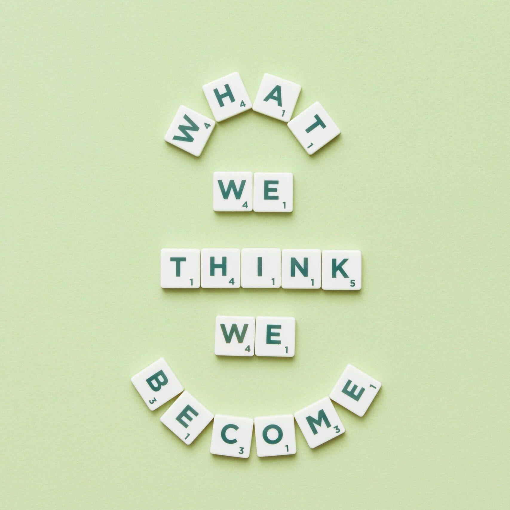 Motivational quote arranged with letter tiles on a light green background.